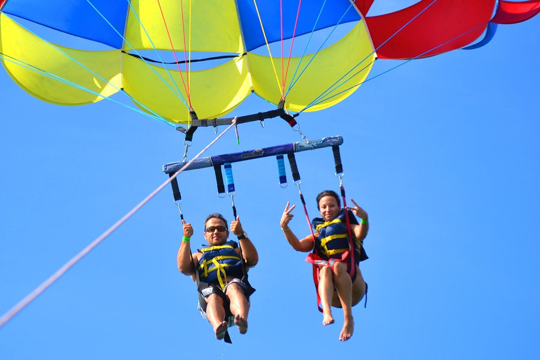 Twee mensen zweven in de lucht met een parachute.