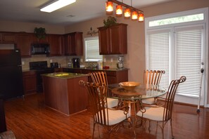 Enjoy cooking in this well-equipped kitchen with a central island, dining table, and modern appliances.