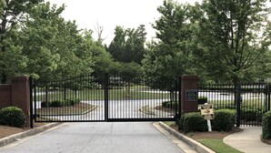 A gated entrance with a brick wall and a sign indicating no trespassing. - Modern 4BR Retreat — Minutes from Mercedes-Benz Stadium - World Cup Ready (Atlanta)