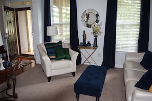 Relax in this stylish living room with a white leather sofa, armchair, and ottoman.