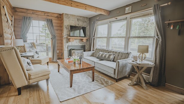 A cozy living room with a fireplace, a sofa, a coffee table, and a television.