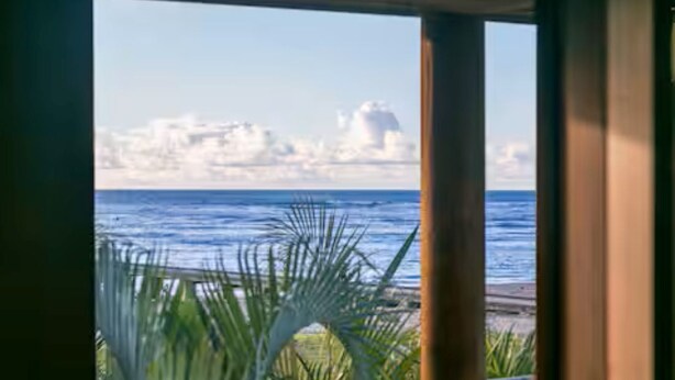 A view from inside a room with a window overlooking the ocean and a beach. - Ocean view Steps to Hanalei Beach TVNC#5087 (Hanalei)