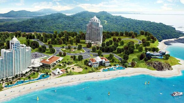 Un resort con varias edificaciones, una playa y vistas al océano y las montañas.