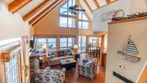 Un vaste espace de vie de style loft, doté de hauts plafonds, de grandes fenêtres et d’un ventilateur de plafond.