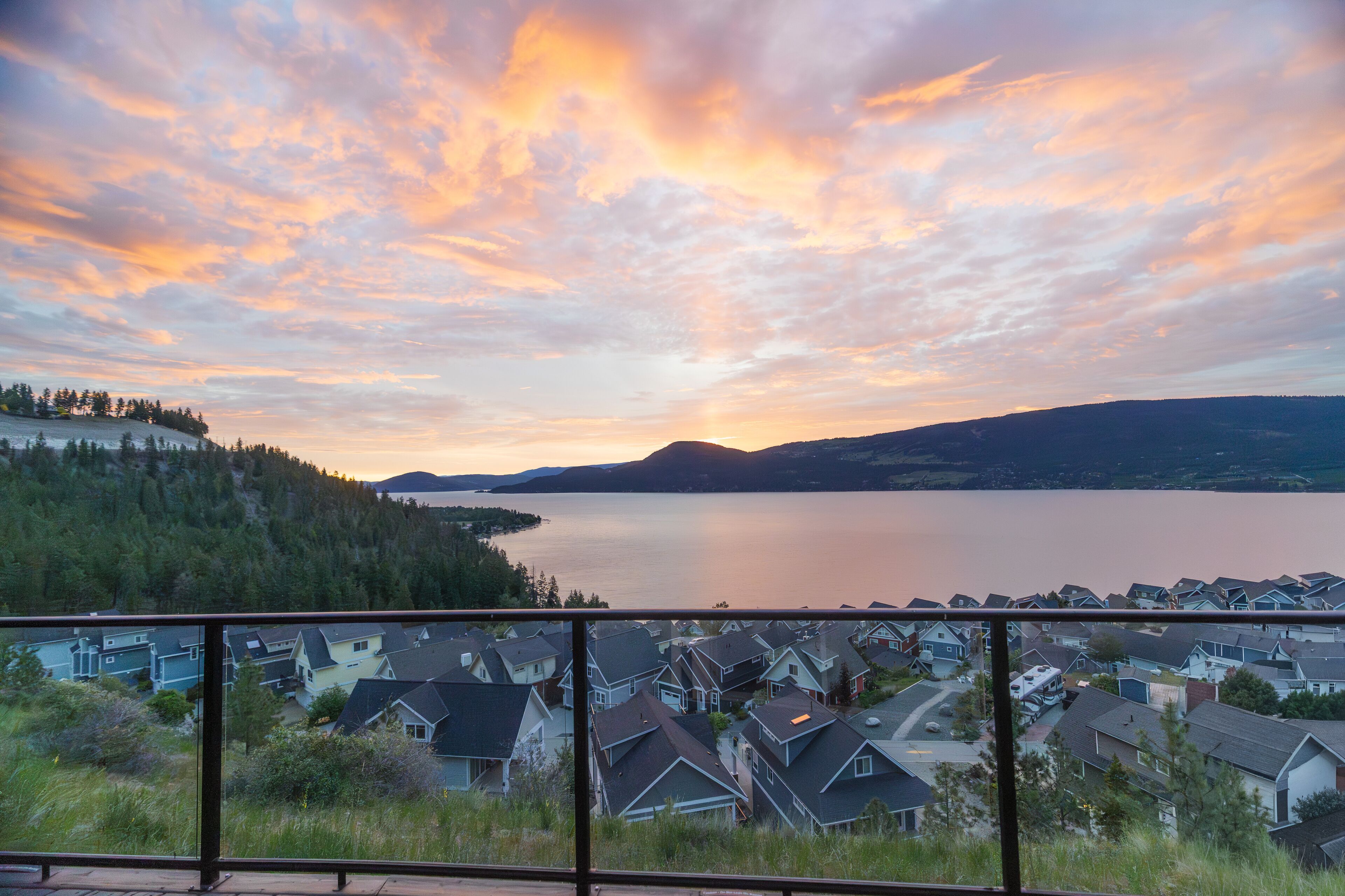 Un quartier résidentiel avec des maisons et un lac, vu depuis un balcon.
