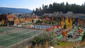Un quartier résidentiel avec des maisons, un court de tennis et une piscine.