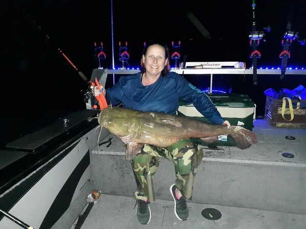 A person holding a large fish on a boat. - Cat Fish Paradise (Rogersville)