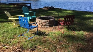 Un cadre idyllique au bord du lac, avec un foyer, des sièges extérieurs et une jetée qui s’avance dans l’eau.