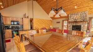 A spacious kitchen with wooden cabinets, a large island, and a stone fireplace. - Views of Grand Lake, Shadow Mountain Lake and RMNP! (Grand Lake)