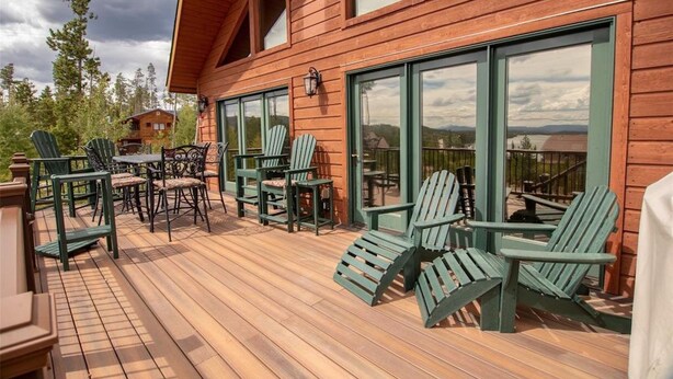 A wooden deck with Adirondack chairs and a table, overlooking a scenic landscape. - Views of Grand Lake, Shadow Mountain Lake and RMNP! (Grand Lake)