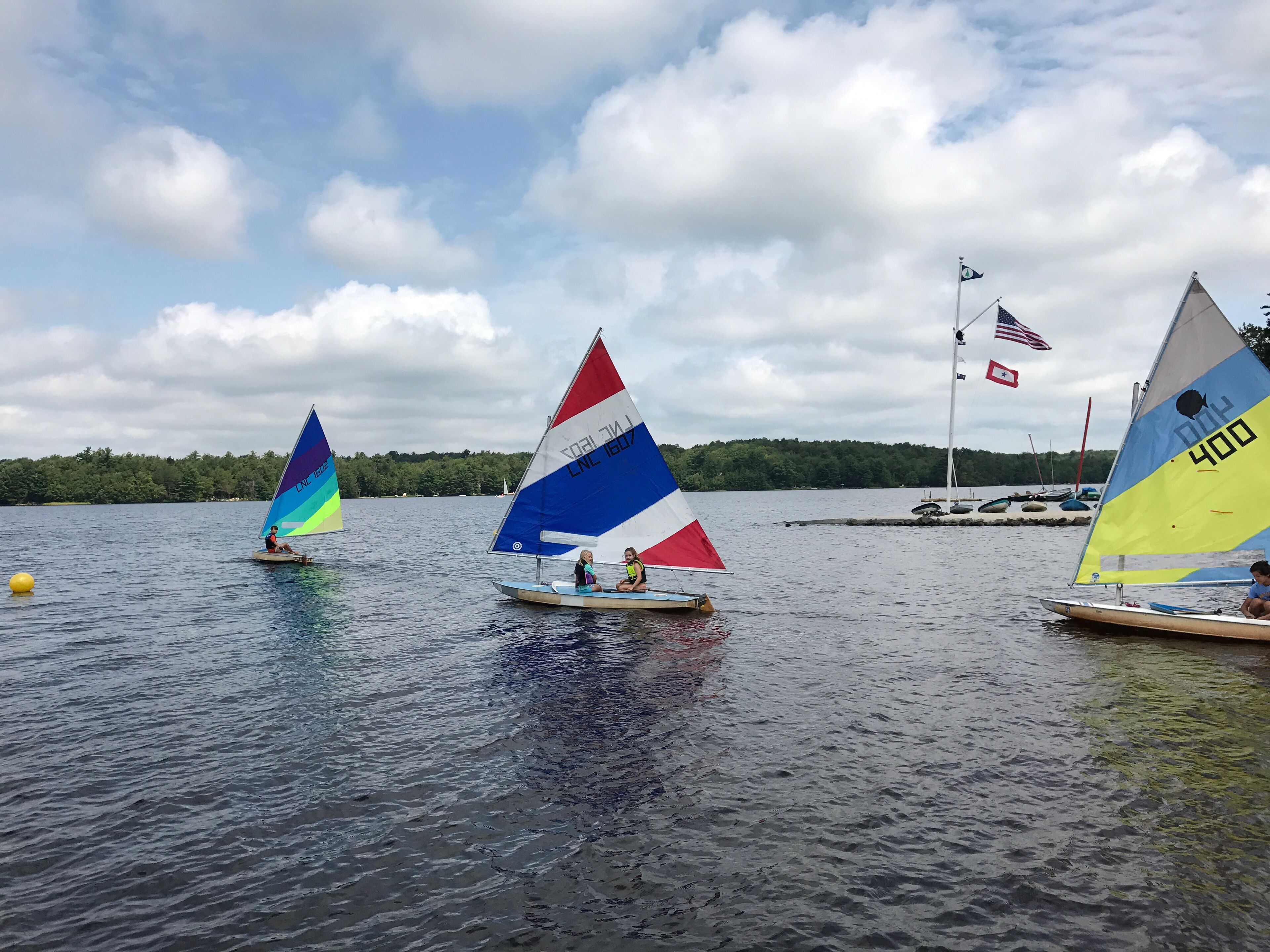 A calm lake with sailboats.