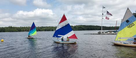 A calm lake with sailboats.