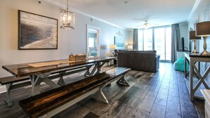 A spacious living area with a wooden bench, a sofa, and a dining table.