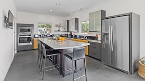 A modern kitchen with a central island, stainless steel appliances, and a large refrigerator. - As featured on CBS's Staycation!
Luxury Retreat Overlooking Sonoma Valley (Glen Ellen)
