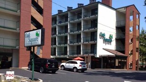 Un hotel de varios pisos con un letrero destacado que dice Oak Square.