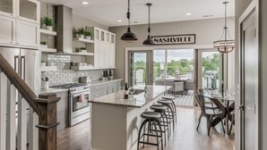 Een moderne keuken met een centraal eiland, barstoelen en uitzicht op de omgeving.