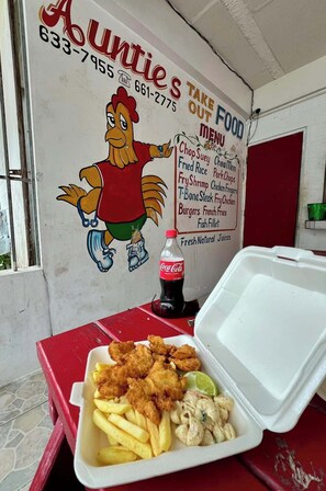 En snabbmatsrestaurang med en menytavla som visar en tecknad höna och olika maträtter.
