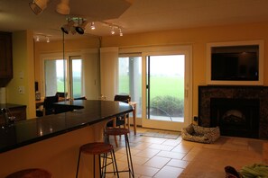 Kitchen and Dining area with sliding glass door to porch and grassy lawn.