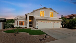 A two-story house with a garage, a well-maintained lawn, and a driveway. - Relaxing Lakefront-Pool-Spa-Pontoon-Game Room-FirePits-Cardinal Stadium-WM Open (Glendale)