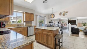 A spacious kitchen with granite countertops, wooden cabinets, and a large island. - Relaxing Lakefront-Pool-Spa-Pontoon-Game Room-FirePits-Cardinal Stadium-WM Open (Glendale)