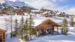 Ein Chalet-Resort mit mehreren Chalets, einer Whirlwanne und einem Grill.