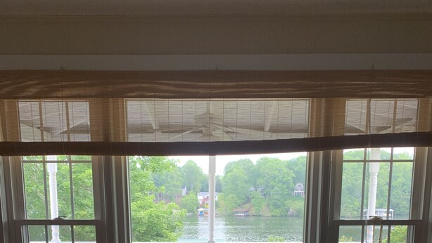A room with a large window overlooking a deck with outdoor furniture. - The Olde Farmhouse Spacious Lakefront House with Amazing View (Goodview)