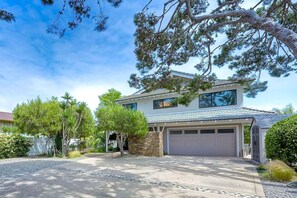 A two-story house with a garage, surrounded by trees and a well-maintained lawn. - Kai Entire Home (5 bedroom / 5 bath) (Carlsbad)