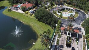 An aerial view of a resort with a swimming pool, a fountain, and a roundabout with a central island.