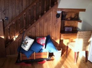 Step into a warm and inviting space with a cozy bench and wicker chair.