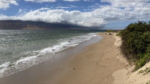 Una playa con cielo despejado y olas.