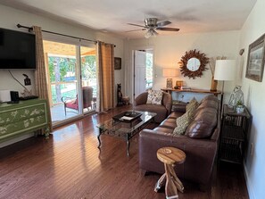 A living room with a sofa, coffee table, and a television on a cabinet.