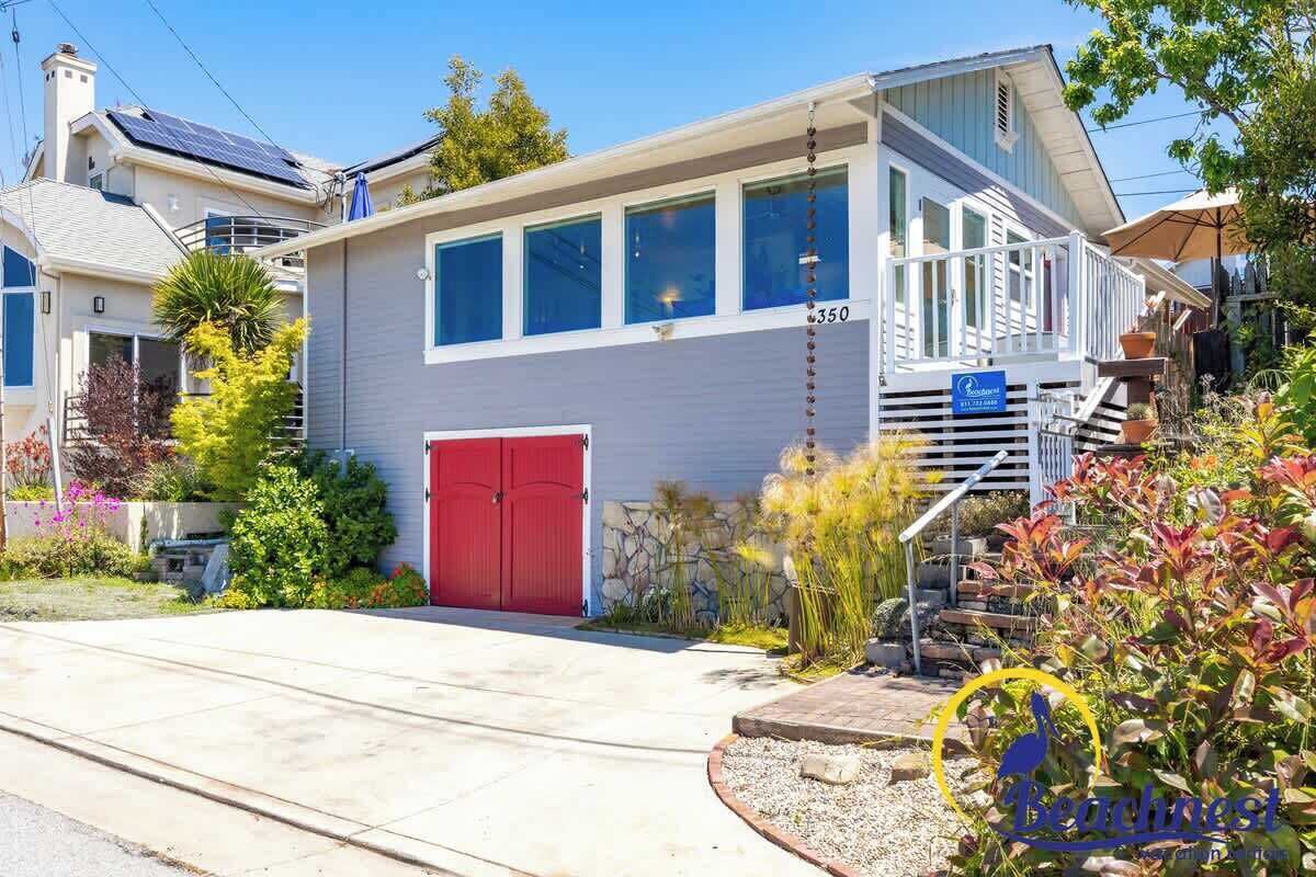 A two-story house with a red garage door, a balcony, and a number '350' on the side.