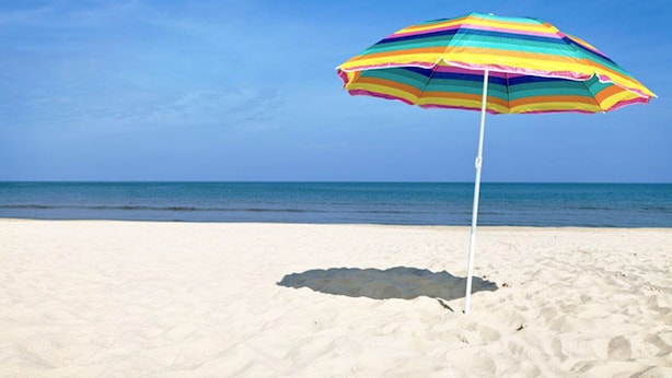 A beach with a colorful striped umbrella. - Tranquil and Spacious Cottage close to South Haven Beaches and Downtown (South Haven)