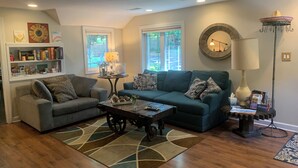 A living room with two sofas, a coffee table, a bookshelf, and a fireplace. - Tranquil and Spacious Cottage close to South Haven Beaches and Downtown (South Haven)