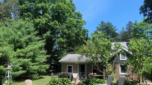 A house with a backyard featuring a fire pit, outdoor seating, and a windmill. - Tranquil and Spacious Cottage close to South Haven Beaches and Downtown (South Haven)