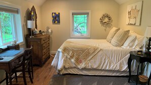 A bedroom with a bed, desk, dresser, and a window with a view of greenery. - Tranquil and Spacious Cottage close to South Haven Beaches and Downtown (South Haven)