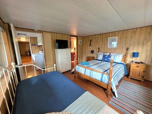 A bedroom with a bed, bedside tables, a wardrobe, and a television.