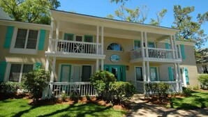 A two-story building with a balcony on the second floor, a small circular window on the first floor, and a sign that reads "Myrtle Inn." - Ocean View 2BR Condo Near Pier Village | St. Simons Island Vacation Rental (St Simons Island)