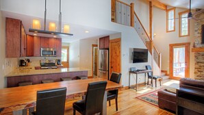 A spacious kitchen with a large island, wooden cabinets, and modern appliances. -  The Perfect Family Mountain Getaway (Breckenridge)