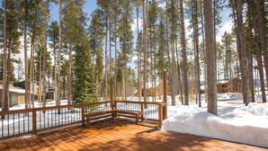 A wooden deck with a railing, surrounded by tall pine trees and snow. -  The Perfect Family Mountain Getaway (Breckenridge)