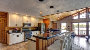 A kitchen with white cabinets, a wooden island, and pendant lighting. - Beautiful 7 Bed, 6 Bath, Huge Dock, Boat Launch @ House, Game Room, Kid Friendly (Sunrise Beach)