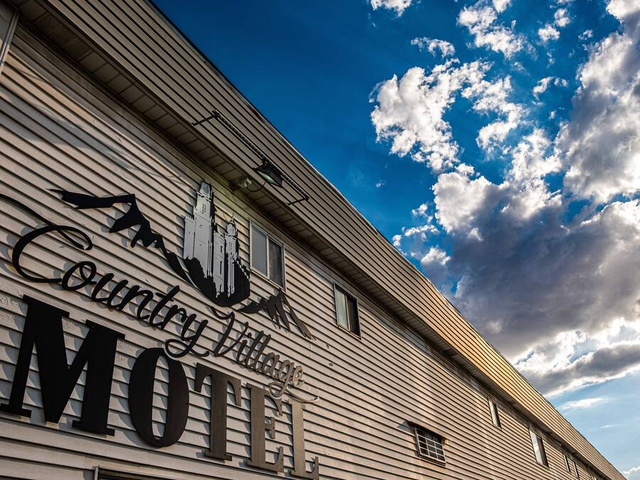 A motel sign with a mountain silhouette and the words "County Village Motel".