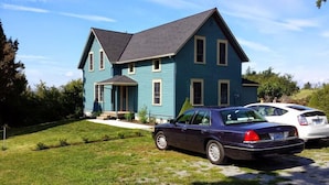 Ein zweistöckiges Haus mit Veranda und Auffahrt.
