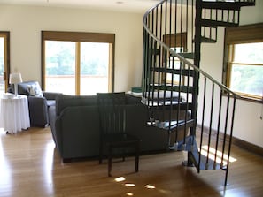 Relax in a spacious living area with a sofa, wooden floor, and cozy reading nook.