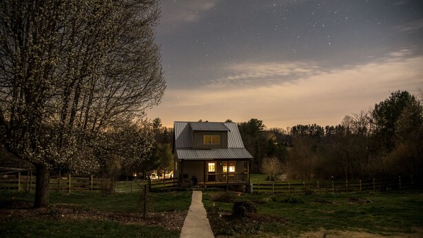 A house with a porch, a pathway leading to it, and a starry night sky. - Garden Cottage near Asheville and Blue Ridge Parkway (Fairview)