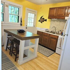 A kitchen with wooden cabinets, a white refrigerator, and a sink.