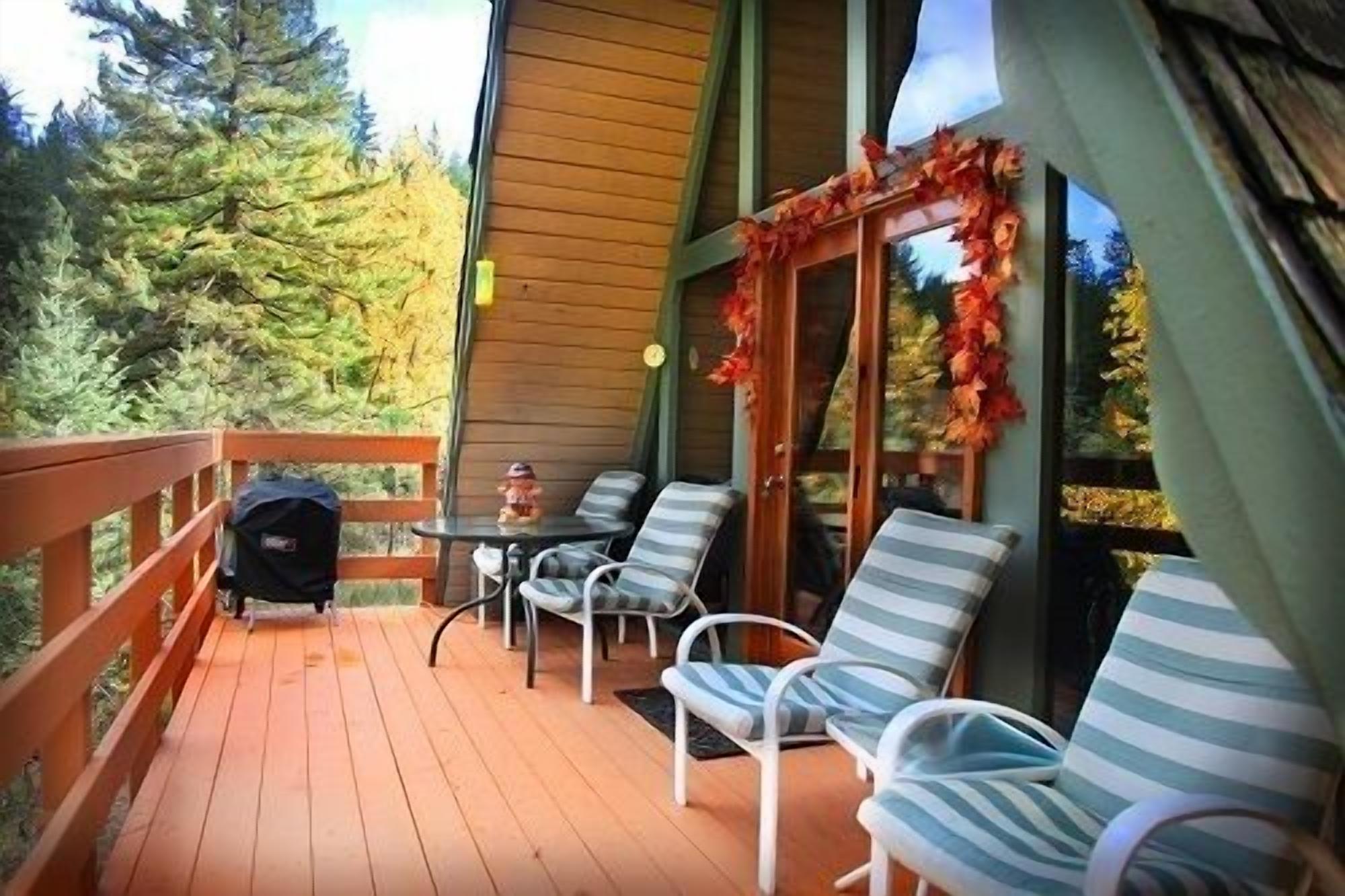 A wooden deck with outdoor seating and a grill.