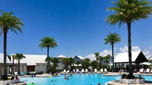 Ein Poolbereich mit Liegestühlen und Palmen.