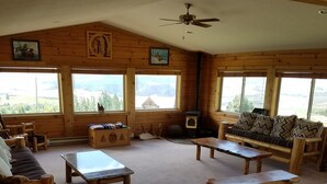 A cozy cabin interior with wooden walls, a ceiling fan, and large windows offering mountain views. - Come stay at the McMinn Inn and enjoy the mountian views! (Inkom)