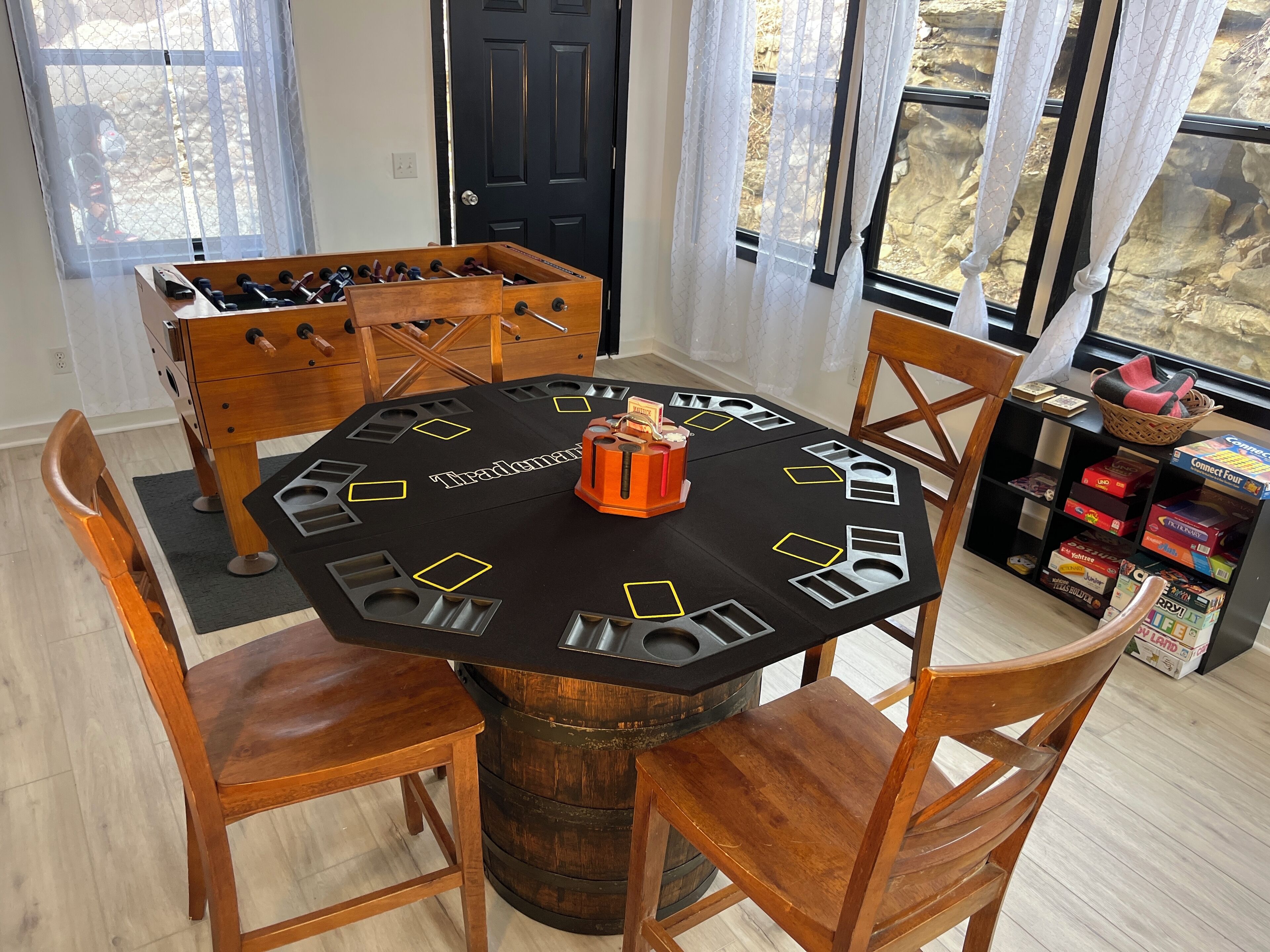 A dining area with a round table, wooden chairs, and a wooden barrel as the table's base.